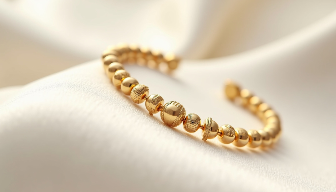 Bracelet Perlée signature de Van Cleef & Arpels en or jaune, montrant le maillon gravé et les perles alternées